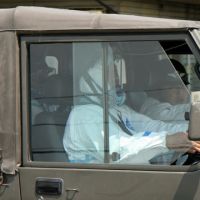 Spring cleaning: At a shopping center on the edge of the 20 km evacuation zone around the Fukushima No. 1 nuclear plant, hazmat-suited military contractors head to Namie for cleanup duties in April. | JACK STONE