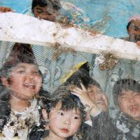 Before: A party photo lies among other tsunami debris in Yuriage town, Miyagi Prefecture, in April 2011. | JACK STONE