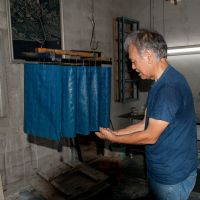 True blue: Indigo-dyed fabrics are hung inside Masanao Shiroma\'s workshop. The dye used is derived from Ryukyu-ai plants, hand-picked  from the Yanbaru Forest of Okinawa. | &#169; TOTAL REAL AG