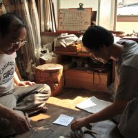 Team arrows (from top): Eiichi Hasegawa and his apprentice Emiko Furuya discuss a resin-holder; his mother, Toshiko, steams the flights on old arrows for repairs; Eiichi checks that nodes align on a set of arrows and trues them with a tamegi tool; apprentice Harumi Akatsuka shows off the point of it all. | KIT NAGAMURA