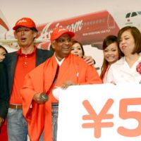 Slice the price: AirAsia group CEO Tony Fernandes holds a sword while the carrier\'s president, Kazuyuki Iwakata, stands next to him Thursday at a Tokyo news conference to announce new flight services in Japan. | AFP-JIJI