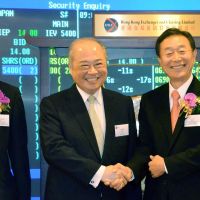 Game of chance: Dynam Japan Holdings Co. President Yoji Sato (right) shakes hands at the Hong Kong Stock Exchange with its chairman, Chow Chung-kong, on Monday. | KYODO