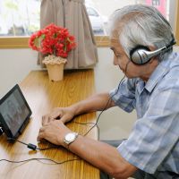 Keeping in touch: Joji Sato, a nuclear evacuee from Iitate, Fukushima Prefecture, chats with Iitate Mayor Norio Kanno using a tablet PC provided by the village. | KYODO