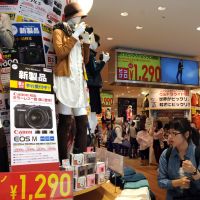 Two for one: A customer checks out a display of mannequins wearing Uniqlo-brand clothes and holding cameras from retailer Bic Camera at Bicqlo, the two brands\' first joint outlet, in Tokyo\'s Shinjuku Ward, on Thursday. | SATOKO KAWASAKI