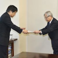 Power play: Michiaki Uriu (right), president of Kyushu Electric Power Co., hands an application for an electricity rate hike to Ichiro Takahara, head of the Natural Resources and Energy Agency, in Tokyo on Tuesday. | KYODO