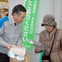 Appeal: An employee of Kyushu Electric Power Co. hands out leaflets asking people to save energy in Fukuoka on Monday. | KYODO