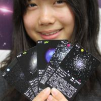 Star search: A student holds up some of the astronomy game cards created by college students and space fans in Tokushima Prefecture. | KYODO PHOTO