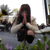 A woman prays at the site of the 2008 stabbing spree in Tokyo\'s Akihabara district on Sunday. The district partially reopened the weekly \"pedestrian paradise\" zone later in the afternoon after closing it off for more than two years after the fatal attack. | AP PHOTO