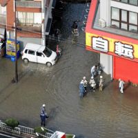 Submerged: Water from a ruptured underground pipe floods a street in Nishi-Yodogawa Ward, Osaka, on Friday. | KYODO PHOTO