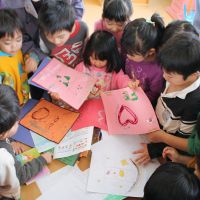 Personal touch: Children at the Torikawa nursery school in the city of Fukushima look over letters from children in the Dominican Republic on Tuesday. | KYODO
