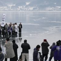 Back to the future: A priest from Yatsurugi Shrine conducts the \"omiwatari\" ritual on Lake Suwa, Nagano Prefecture, on Feb. 6. | CHUNICHI SHIMBUN
