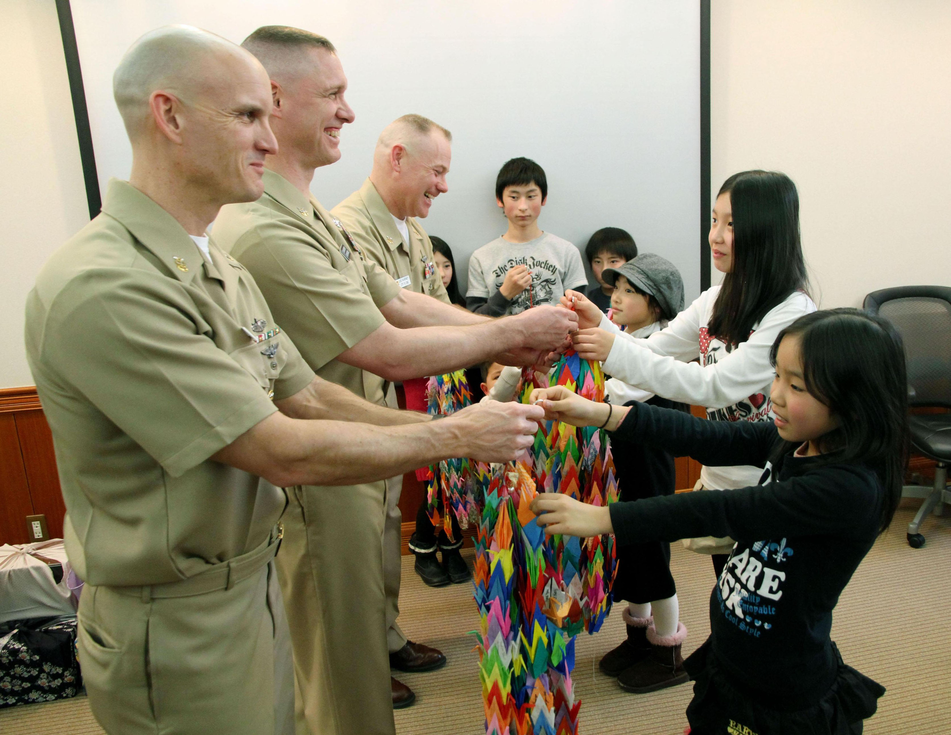 Friends: Evacuees hand paper cranes to U.S. servicemen Feb. 24 at the U.S. Navy base in Yokosuka, Kanagawa Prefecture. The cranes, made by 650 evacuees from Minamisoma, Fukushima Prefecture, contain messages of thanks for Operation Tomodachi. | KYODO