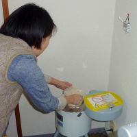 Home-made: A woman measures out rice bran to test it for radioactivity in Yokohama on Monday. | KYODO