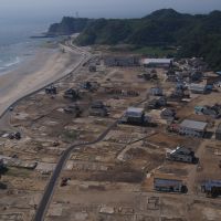 Eye in the sky: A photo shot by Eiji Sakai while paragliding in May 2008 shows Iwaki\'s once thriving community in Fukushima Prefecture. Below: A picture of the same area last July shows that virtually all that remains are empty lots. | EIJI SAKAI