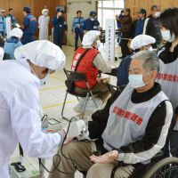Just in case: Residents of the town of Wakasa, Fukui Prefecture, are screened for radiation contamination during a disaster drill held Sunday near the Tsuruga nuclear power plant. | KYODO