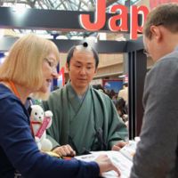 An official working for Nikko Edo Mura, or Edo Wonderland, in Nikko, Tochigi Prefecture, gives a presentation to visitors at an international tourism trade fair in Moscow on Wednesday. | KYODO