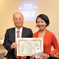 Medical citation: Indonesian nurse Dewi Rachmawati poses for a photo with Hidenori Sakamaki, head of the Japan Immigration Policy Institute, after being presented with a special prize on Dec. 18 in Tokyo for an essay she wrote about her struggles to become a nurse in Japan. | YOSHIAKI MIURA