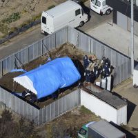 Grisly find: Police go over a lot in Kuki, Saitama Prefecture, where Makoto Shimomi was found slain Tuesday along with a murdered woman believed to be his wife, Mie. | KYODO