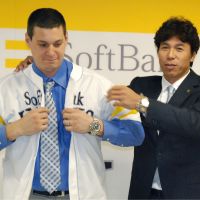 Ready to fly: Hawks manager Koji Akiyama helps new acquisition Bryan LaHair into his jersey on Wednesday in Fukuoka. | KYODO