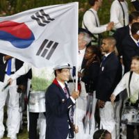 Know your country: Yoon Kyun Shin carries the South Korean flag during Friday night’s Opening Ceremony. Advertisers have fun with 'Flag-gate'