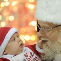 Seeing is believing: A baby takes a close look at John Parks, playing the role of Santa Claus, as he greets children at an elementary school in Ashburn, Virginia. | THE WASHINGTON POST