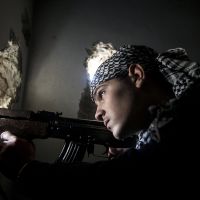 Reinforcements: A Free Syrian Army fighter aims his weapon during clashes with government forces in Aleppo on Dec. 10. | AP