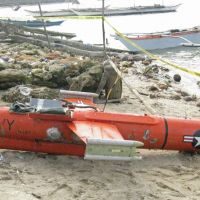 Lost and found: A U.S. drone is shown on a beach in the town of San Jacinto last week after Filipino fishermen found the 3.65-meter device floating off Masbate Island and dragged it ashore. | AFP-JIJI