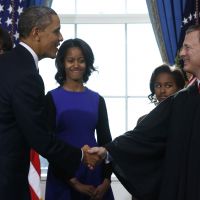 Oath of office: President Barack Obama shakes hands with Chief Justice John Roberts after Obama was officially sworn in for his second term as first lady Michelle Obama and daughters Malia (left) and Sasha watch at the White House in Washington on Sunday. | AP