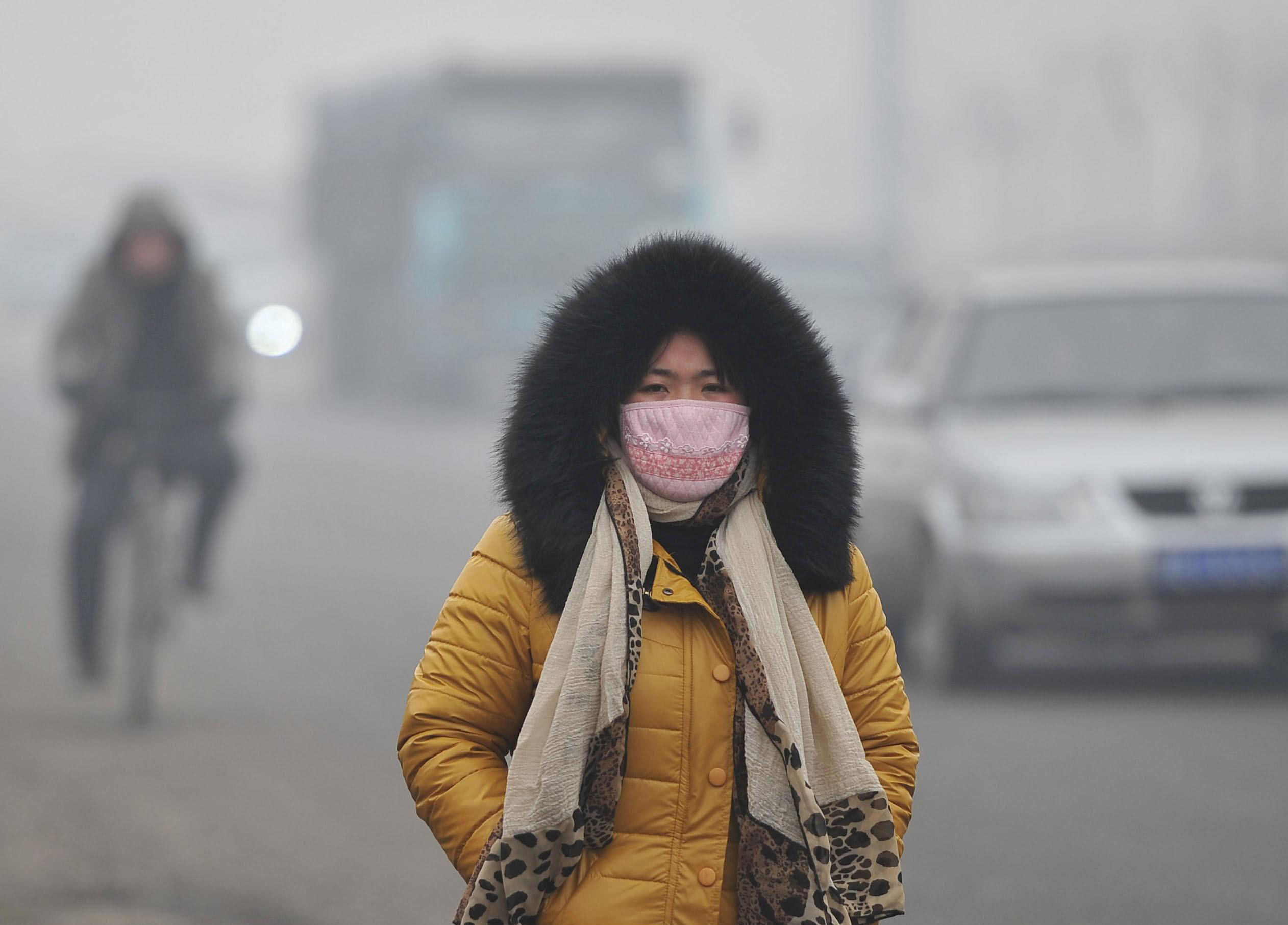 Chemical soup: A woman wears a mask Sunday as she braves the polluted streets of  Tangshan, Hebei Province, China. | KYODO