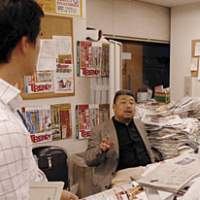 Nikkei Trendy\'s Editor-in-Chief Mori Kiramura briefs his staff from behind his desk weighed down with test reports and product specifications. | PHOTOS COURTESY OF THE MORI ART MUSEUM