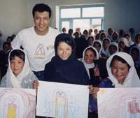Ethnic Hazara girls with Hector Sierra in Bamyan, Afghanistan, display their renderings of “My City” in May 2002, just a few months after the Taliban had left. Earlier, the girls had not been permitted to attend school or even to draw. Earlier, the girls had not been permitted to attend school or even to draw. Children smile again thanks to art of healing