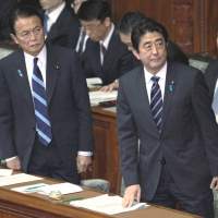 Eyes right, again: Prime Minister Shinzo Abe (right) and his deputy and finance minister,  Taro Aso, of the Liberal Democratic Party are back in control of Japan after both being forced out of the prime ministerial job within a year in 2007 and 2009, respectively. | BLOOMBERG