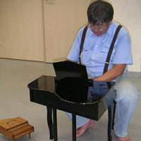 An artist plays a toy piano. | EMYU PHOTO