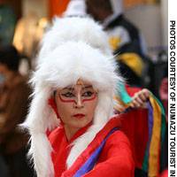Clad in colorful costumes, local women march and dance on the streets of Numazu City during the Yosakoi Tokaido Festival last fall. | Photo by Judit Kawaguchi