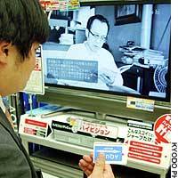 A customer holds a special B-CAS user identification card at Bic Camera\'s outlet in Yurakucho, Tokyo. | TOMOKO OTAKE PHOTO