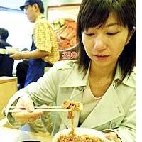 A customer tries the reinstated \"gyudon\" beef-on-rice bowl at Matsuya Foods Co.\'s restaurant in the Kabuki-cho district of Tokyo\'s Shinjuku Ward. | TAIGA URANAKA PHOTO