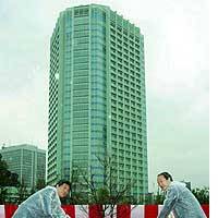 Architect Noritaka Tange (left) and Minato Ward Mayor Masaaki Takei plant a tree Monday to commemorate the opening of the Tokyo Prince Hotel Park Tower. | TAIGA URANAKA PHOTO