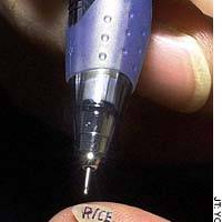 A Mitsubishi Pencil Co. pen with a 0.18 mm diameter ball was used to write \"rice\" on a grain of rice. | KAHO SHIMIZU PHOTO