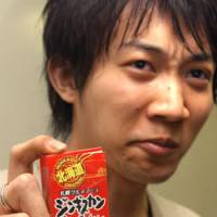 Graduate student Noriyuki Suzuki is unimpressed with the taste of Genghis Khan caramels manufactured by Sapporo Gourmet Foods Co. | SATOKO KAWASAKI PHOTO