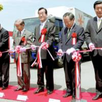 Agriculture minister Toshikatsu Matsuoka (center) joins officials of meatpacking companies during a ceremony marking the resumption of beef exports to Hong Kong in Soo, Kagoshima Prefecture, on Monday. | KYODO PHOTO