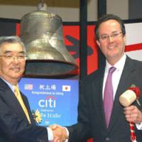 Citigroup japan Holdings CEO Douglas Peterson (right) celebrates his firm\'s Monday share listing on the Tokyo Stock Exchange after ringing the bell next to TSE President Atsushi Saito. | SATOKO KAWASAKI PHOTO