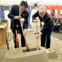 Banking on batteries: Shinichi Fukushima (right), senior management director of Panasonic Corp., takes part in a groundbreaking ceremony Monday for a new lithium-ion battery plant in Suminoe Ward, Osaka. | KYODO PHOTO