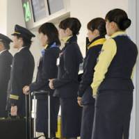 Ready to go: Pilots and cabin crew from Skymark Airlines wait at Haneda airport in Tokyo on Friday. | KYODO PHOTO