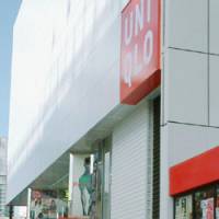 Turf war: People walk by a new Uniqlo outlet that opened Friday on the west side of JR Shinjuku Station in Tokyo. | KYODO PHOTO