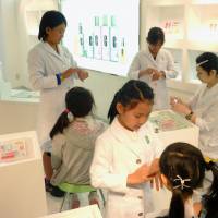 Job training: Girls pretend to be beauty consultants and customers in a mock cosmetics store at KidZania Tokyo on Nov. 2. | KYODO