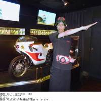 Paying homage: An employee at Kamen Rider the Diner, a restaurant in Tokyo\'s Ikebukuro district based on the popular TV series, performs Kamen Rider No. 1\'s \"henshin\" (transformation) ritual in front of the Cyclone motorbike used in the show. | KYODO