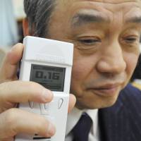 Sounding off: A man holds a Geiger Fukushima, a radiation detector developed for the visually impaired, in the city of Fukushima on Friday. | KYODO