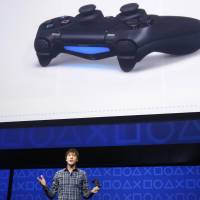 Taking control: A Sony official explains the controller features on the PlayStation 4 during an event in New York on Wednesday announcing the release of the new game console. | REUTERS/KYODO