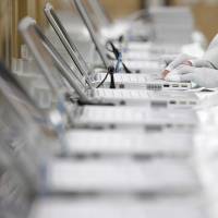 Lithium-ion powered: A worker configures the software system and programs on Panasonic Corp. laptop computers at the company\'s plant in Kobe in February 2012. | BLOOMBERG