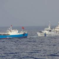 Closely shadowed: Coast guard cutters tail a Chinese fishing boat Saturday off Miyako Island in Okinawa Prefecture before officers boarded the vessel and arrested its captain on suspicion of illegally operating in Japan\'s exclusive economic zone. | JAPAN COAST GUARD/AP